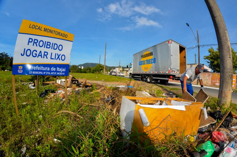 Terreno baldio com placa de proibido jogar lixo.