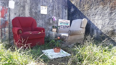 Sofá e entulho em terreno baldio